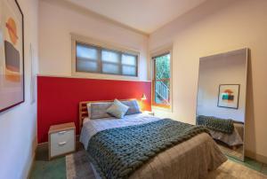 a bedroom with a bed and a red wall at Historic Hood River Retreat with Stunning Gorge Views - Roe Parker House in Hood River