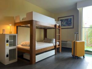 a bunk bed in a room with a suitcase at Bposhtels Orlando Florida Mall in Orlando