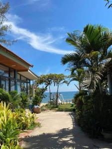 a house with a palm tree next to the ocean at Seasand Quảng Bình - by BAY LUXURY in Dong Hoi