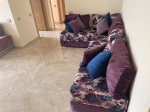 a couch with pillows on it in a living room at À LOUER APPARTEMENT à Casabay in Sidi Rahal +1 photo