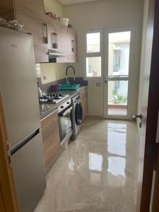 a kitchen with a stove and a refrigerator at À LOUER APPARTEMENT à Casabay in Sidi Rahal