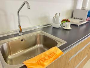 a stainless steel kitchen sink with a kitchen towel at The Cosmic - Icon City Petaling Jaya in Petaling Jaya