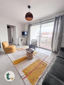 un soggiorno con un divano e una grande finestra di Tranquiloue - Appartement neuf proche PuyduFou ! a Les Herbiers