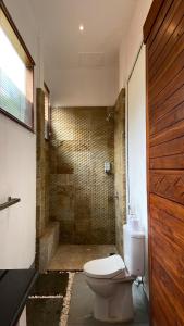 une salle de bain avec toilettes et douche dans l'établissement De Padma Gili Air, à Gili Air