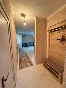 un corridoio con una porta che conduce a una stanza con una panca di Квартира посуточно жана кала a Tridtsatʼ Let Kazakhstana