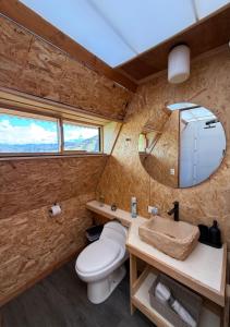a bathroom with a toilet and a mirror at Cabaña Mirador Serena en Villa de Leyva in Rodecia