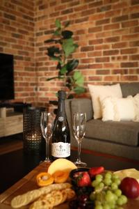 a table with a bottle of wine and two glasses at Hunter Valley 2 x Homes Pets Heated Pool in Whittingham