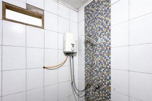a shower in a bathroom with a tile wall at RedDoorz at Argapuri Resort Gambung in Gambung