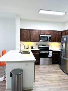 a kitchen with wooden cabinets and a counter top at The Frisco Upscale in Frisco +2 photos