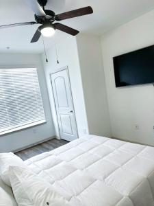 a bedroom with a white bed and a ceiling fan at The Frisco Upscale in Frisco