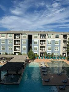 a large building with a swimming pool in front of a building at The Frisco Upscale in Frisco
