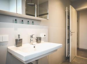 a bathroom with a white sink and a mirror at Exklusives Apartment Sinsheim Luxus, 75 TV & Top Lage WeHome Premium in Sinsheim