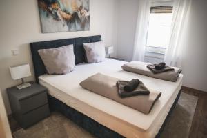 a bedroom with a bed with two pillows on it at Exklusives Apartment Sinsheim Luxus, 75 TV & Top Lage WeHome Premium in Sinsheim
