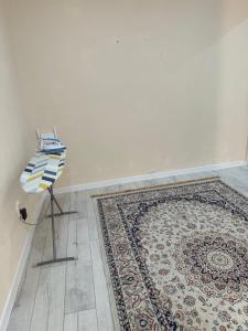 a room with a rug on the floor and a white wall at Уютные апартаменты с видом на реку Иртыш in Semey