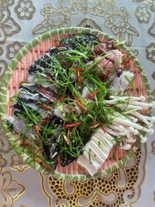 a plate of food with vegetables on a table at Seasand Quảng Bình - by BAY LUXURY in Dong Hoi