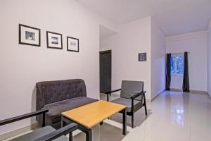 a waiting room with a couch and a table and chairs at Hotel O SS Skyline in Hyderabad