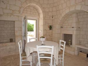 una sala da pranzo con un tavolo e sedie bianche di Country House in Apulia near Alberobello a Cisternino