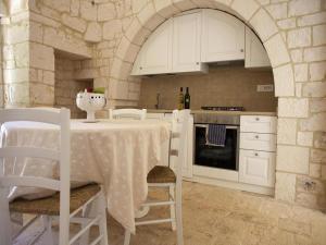 una cucina con un tavolo con sedie e una stufa di Country House in Apulia near Alberobello a Cisternino Altre 19 foto