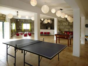 a ping pong table in the middle of a room at Granite House by Tâmega with Pool in Luzim