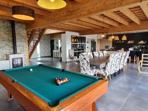 ein Wohnzimmer mit Billardtisch und ein Esszimmer in der Unterkunft Spacieux gîte contemporain avec terrasse panoramique et piscine chauffée - FR-1-584-373 in Favières