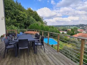 eine Terrasse mit Tischen und Stühlen sowie einen Pool in der Unterkunft Spacieux gîte contemporain avec terrasse panoramique et piscine chauffée - FR-1-584-373 in Favières
