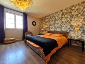 ein Schlafzimmer mit einem großen Bett mit orangefarbener Bettwäsche in der Unterkunft Spacieux gîte contemporain avec terrasse panoramique et piscine chauffée - FR-1-584-373 in Favières