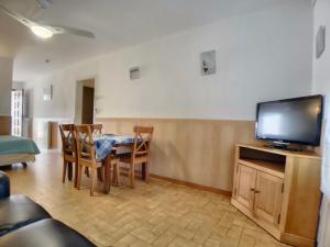 un salon avec une table à manger et une télévision dans l'établissement Appartement 6 pers, jardinet privatif, WiFi - FR-1-475-145, à Saintes-Maries-de-la-Mer 2 autres photos