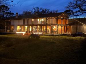 ein großes Haus mit einem davor geparkt in der Unterkunft Domaine de Coursat avec piscine chauffée et services haut de gamme pour 16 personnes - FR-1-791-35 in Castets