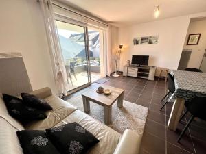 a living room with a couch and a table at Étel: Appartement T2, Terrasse Sud, Près du Port, Parking, Animaux Permis - FR-1-479-218 in Étel