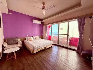 a bedroom with purple walls and a bed and a chair at I WoW in Xiaoliuqiu