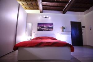 a bedroom with a red bed in a white room at Visit Florentia Apartment in Florence