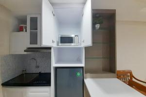 Beran-kidulCozy Studio Room at Patraland Amarta Apartment By Travelio的小厨房配有白色橱柜和微波炉