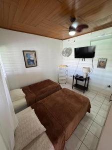 a bedroom with two beds and a flat screen tv at Casa Arcia in Rivas