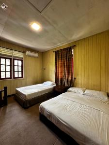 a bedroom with two beds and a window at Kembara Resort, Merang in Setiu +63 photos