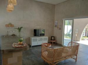 a living room with a television and a table and chairs at BUDDY Villas - LOMBOK in Pawenang