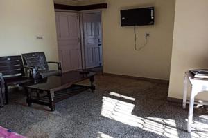 DentamChaayatal Heritage Home by StayApart的客厅里有一张沙发，墙上有一台电视 更多19张照片