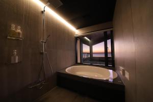 小豆岛Private luxury villa with ocean view Shodoshima的带浴缸和窗户的浴室