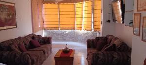 a living room with two couches and a window at residencias lalamar in Chichiriviche