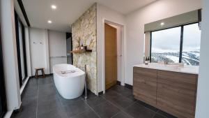 a bathroom with a tub and a sink and a window at Whitemount in Mount Hotham +15 photos