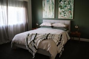 a bedroom with a bed with green walls and a window at 41 Found - Lux Vintage Home with Outdoor Bath in Somerset