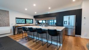 a kitchen with a large island with bar stools at Whitemount in Mount Hotham