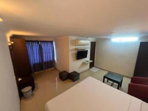a small living room with a couch and a television at Hotel City Tower, Chennai Central in Chennai
