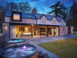 a large house with a hot tub in the yard at Eskdale Retreat in Holmrook