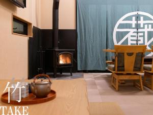 - un salon avec une cheminée, une table et des chaises dans l'établissement ALL SEASON RESORT No5 Kura, à Ichinomiya