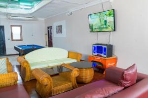 Il comprend un salon doté d'un mobilier en osier et d'une télévision à écran plat. dans l'établissement บีบีพลูวิลล่า2025, à Nong Prue