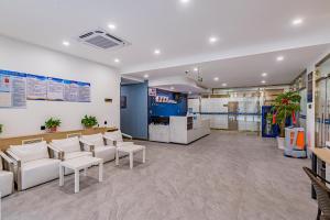 a waiting room with white chairs and tables at GELIhotel Nanchang Road Branch in Nanyuan