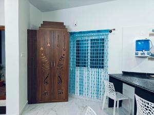 a kitchen with a wooden cabinet and a table at Aarunya Homestay Chitradurga pet friendly in Chitradurga