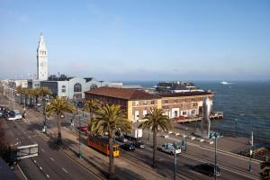 una città con una torre dell'orologio e una strada con palme di Hotel Griffon a San Francisco