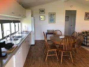 a kitchen with a table and chairs and a sink at The Cottage in Tingoora