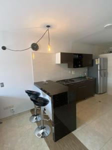 a kitchen with a black counter and a refrigerator at Apartamento En Villa del Prado in Cali +3 photos